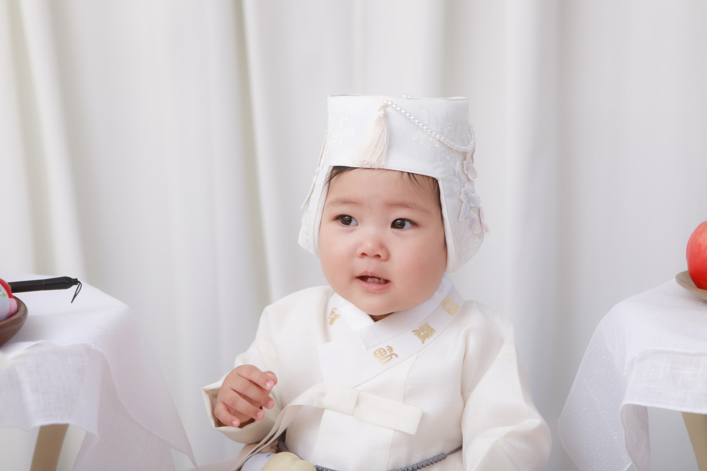 흰 한복과 복건을 쓴 첫돌 아기 얼굴